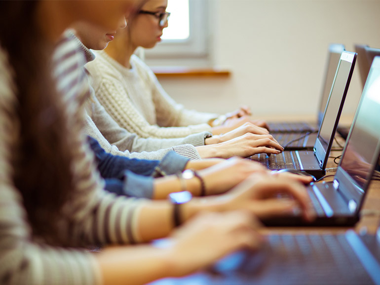 Vier Studierende arbeiten an Laptops