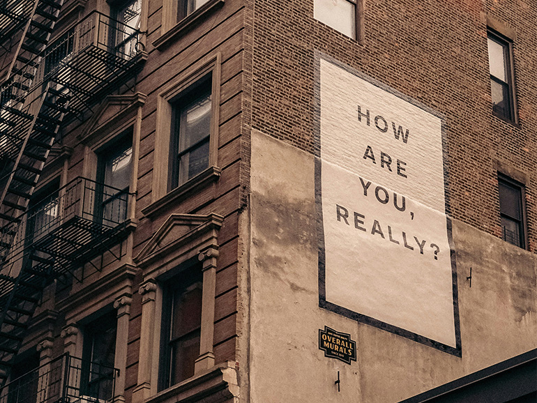 Eine Hauswand mit dem Schriftzug "How are you, really?"